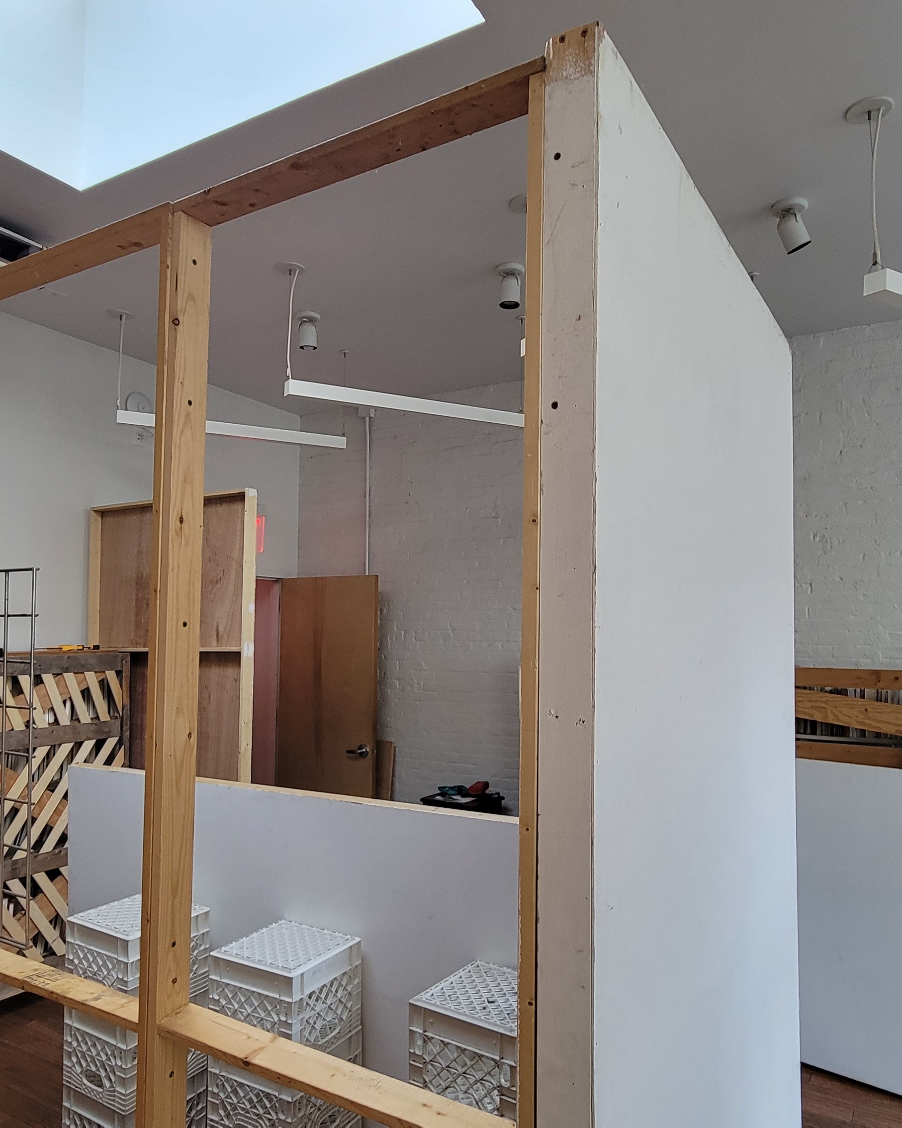 A room bisected by a tall wooden frame, as if a new wall was being built.