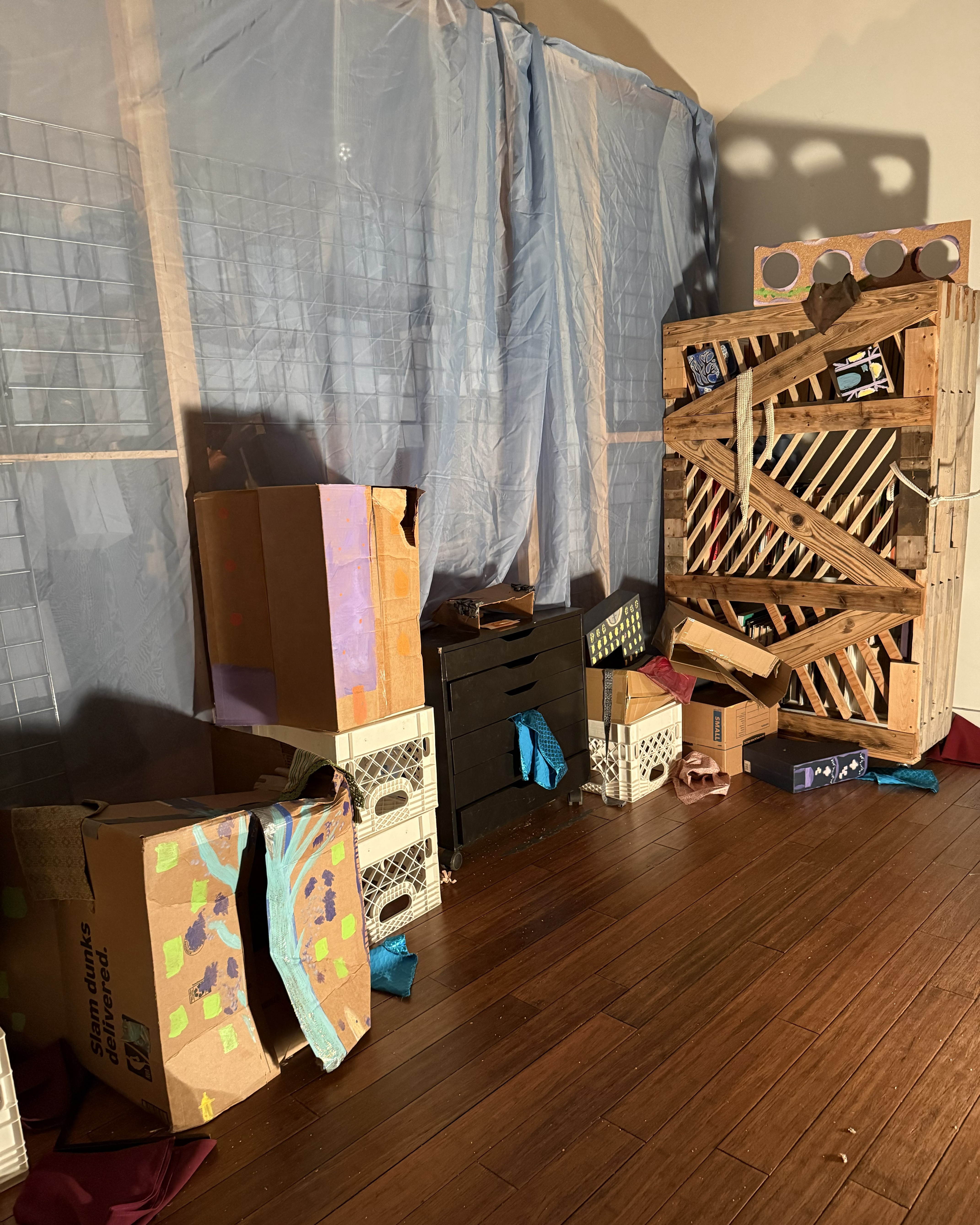 A chaotic arrangement of painted boxes, crates, and miscellaneous objects.